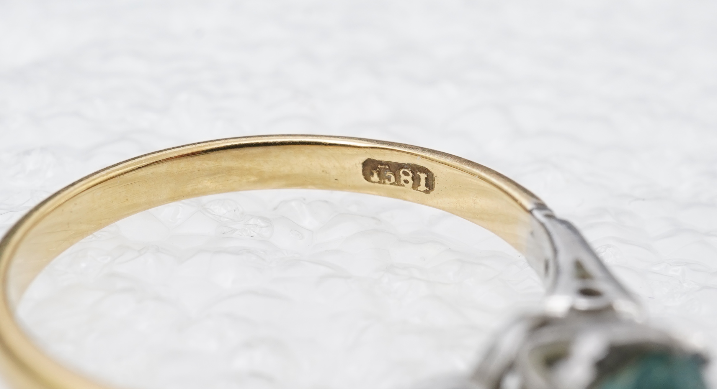 A zircon and diamond ring, mid 20th century, claw-set with a brilliant-cut blue zircon measuring approximately 5mm diameter, to shoulders set with rose-cut diamonds, mounted in gold, size N, stamped 18CT, gross weight ap